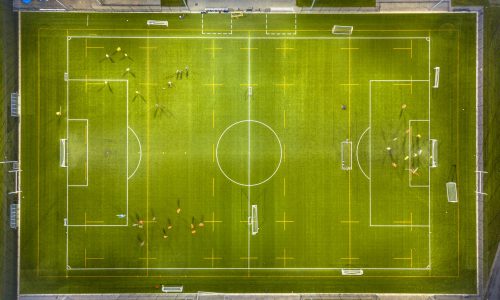 Aerial view of soccer field while athletes are training at night under bright stadium lights